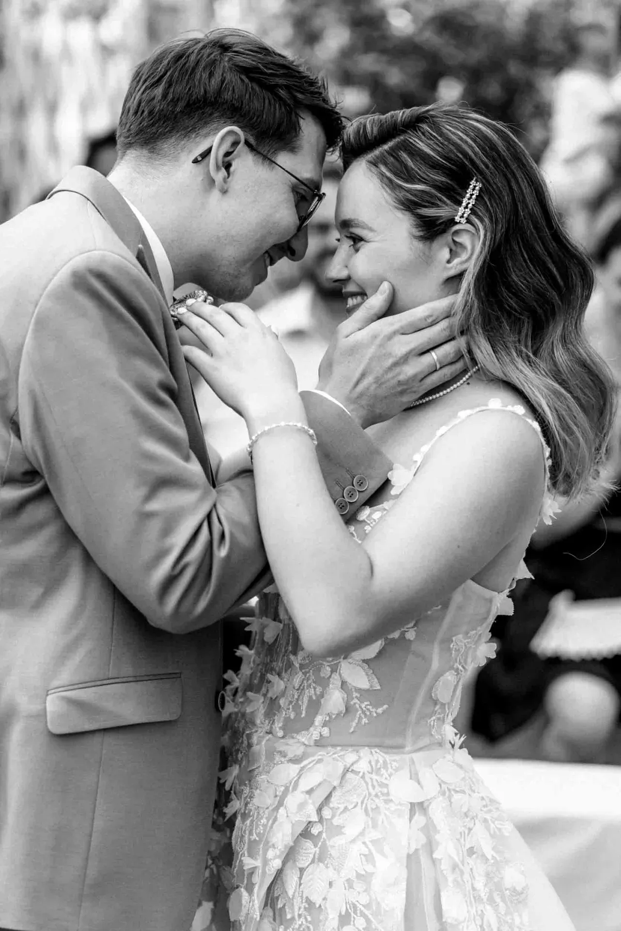Ein Brautpaar hält sich bei einer kleinen Hochzeit liebevoll an den Händen und schaut sich tief in die Augen.