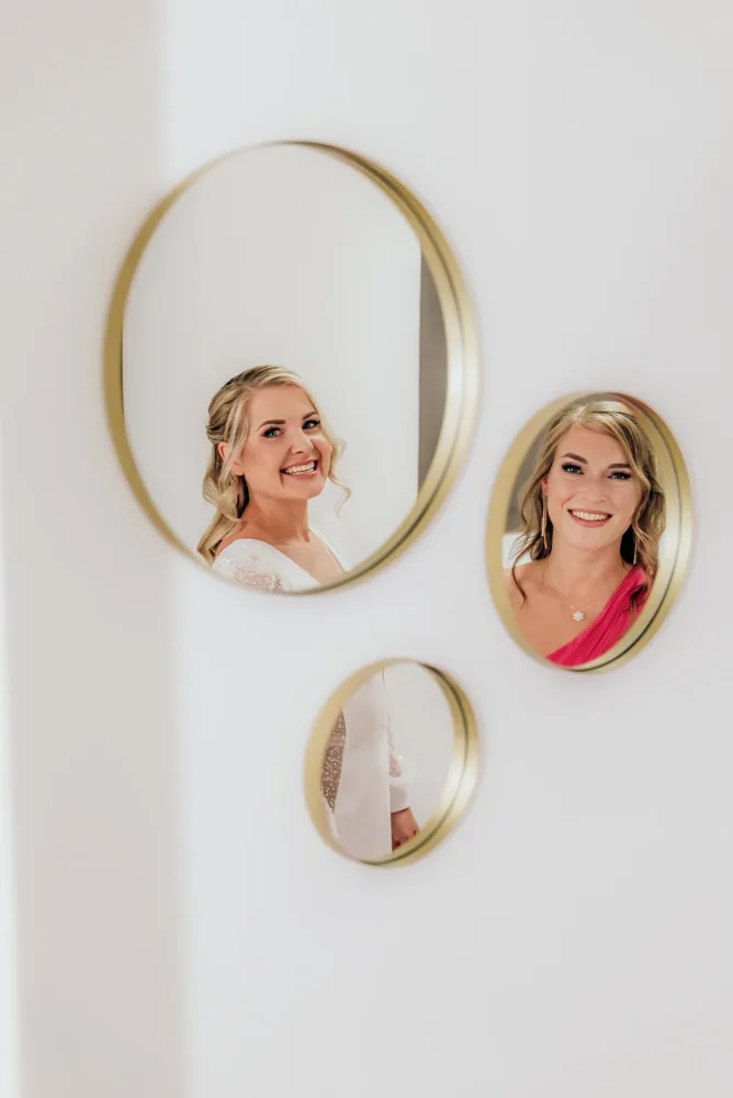 Drei goldgerahmte Spiegel an einer weißen Wand. Hochzeitsfotograf MOKATI