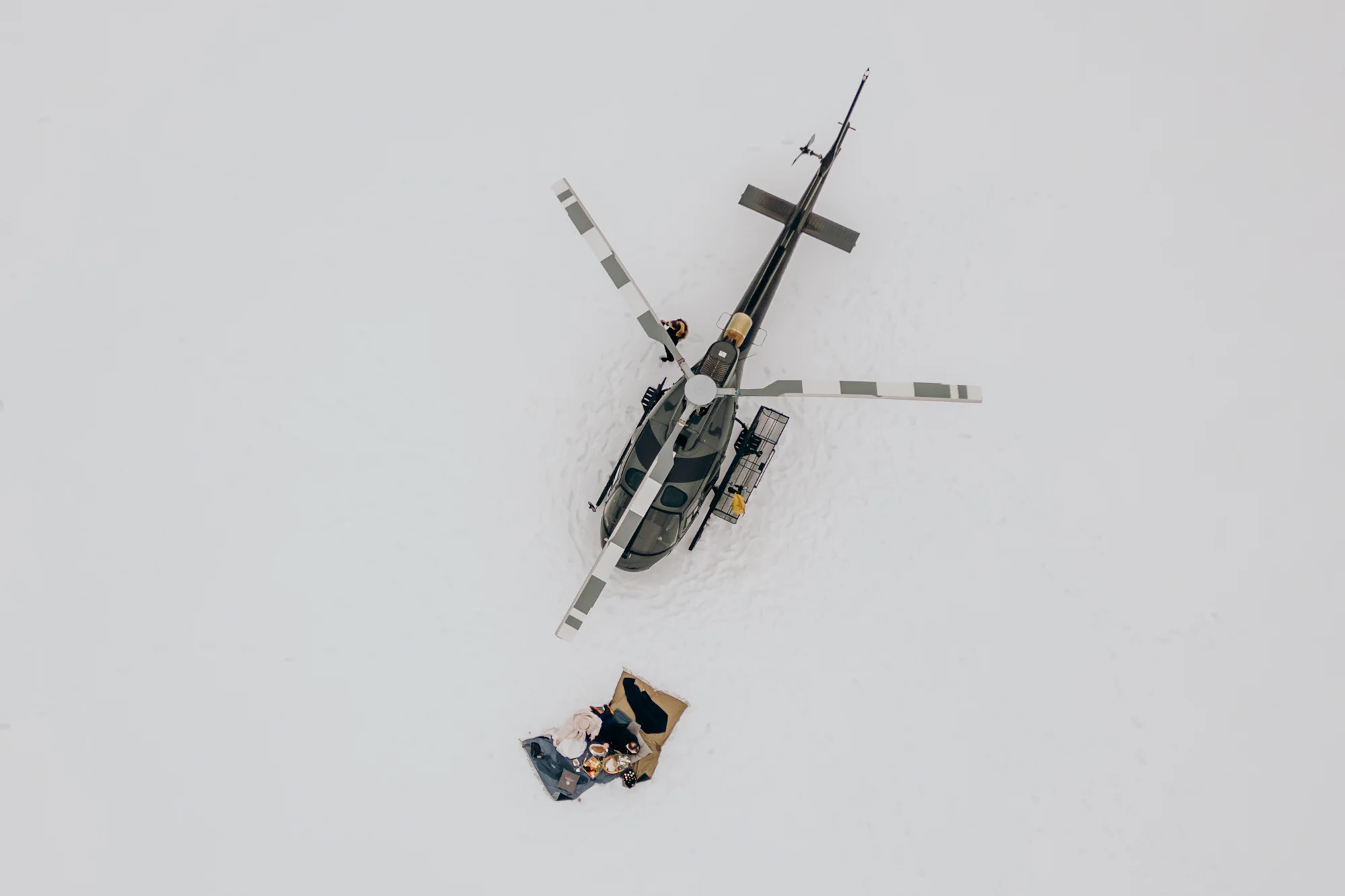 Schwarzer Hubschrauber auf schneebedecktem Gipfel – Hochzeitsreportage MOKATI
