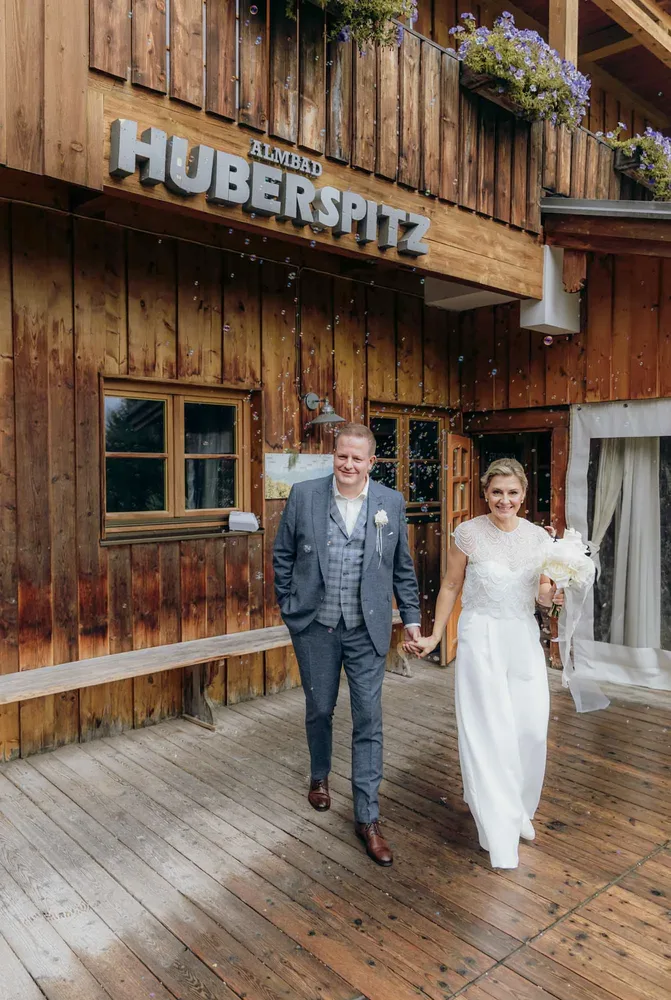 Braut legt ihre Hand an den Anzug des Bräutigams bei einer Hochzeit am Tegernsee