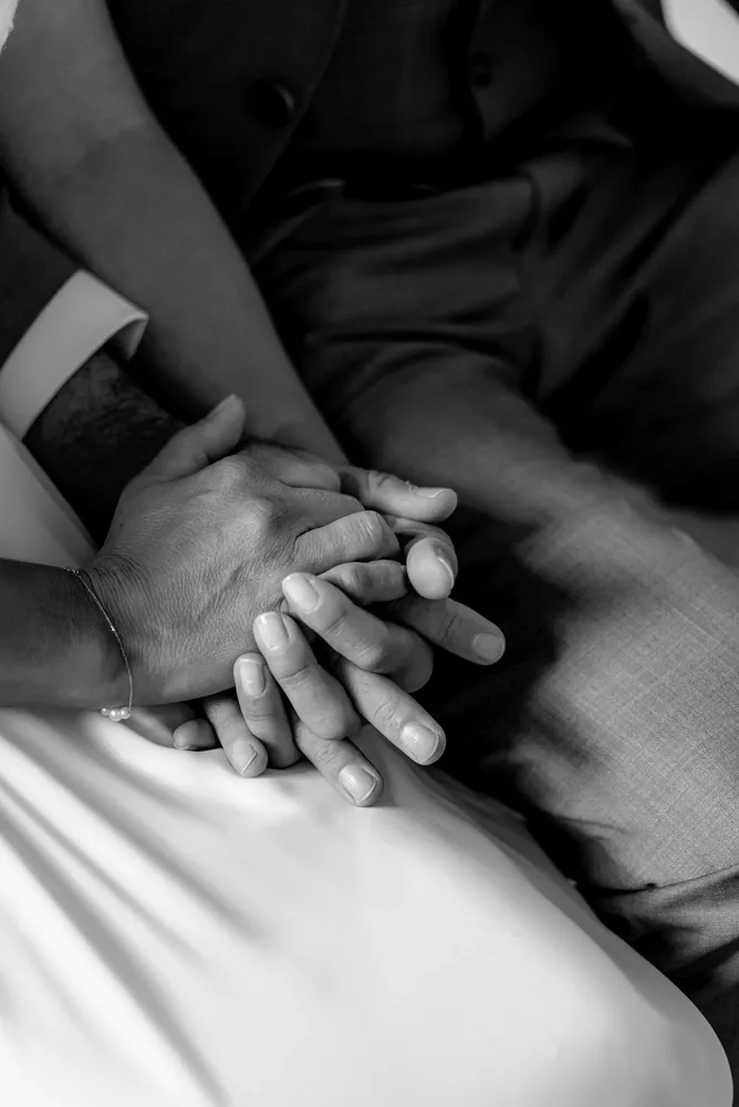 Schwarz-Weiß-Aufnahme von zwei Händen, die sich sanft halten. Hochzeitsfotograf MOKATI