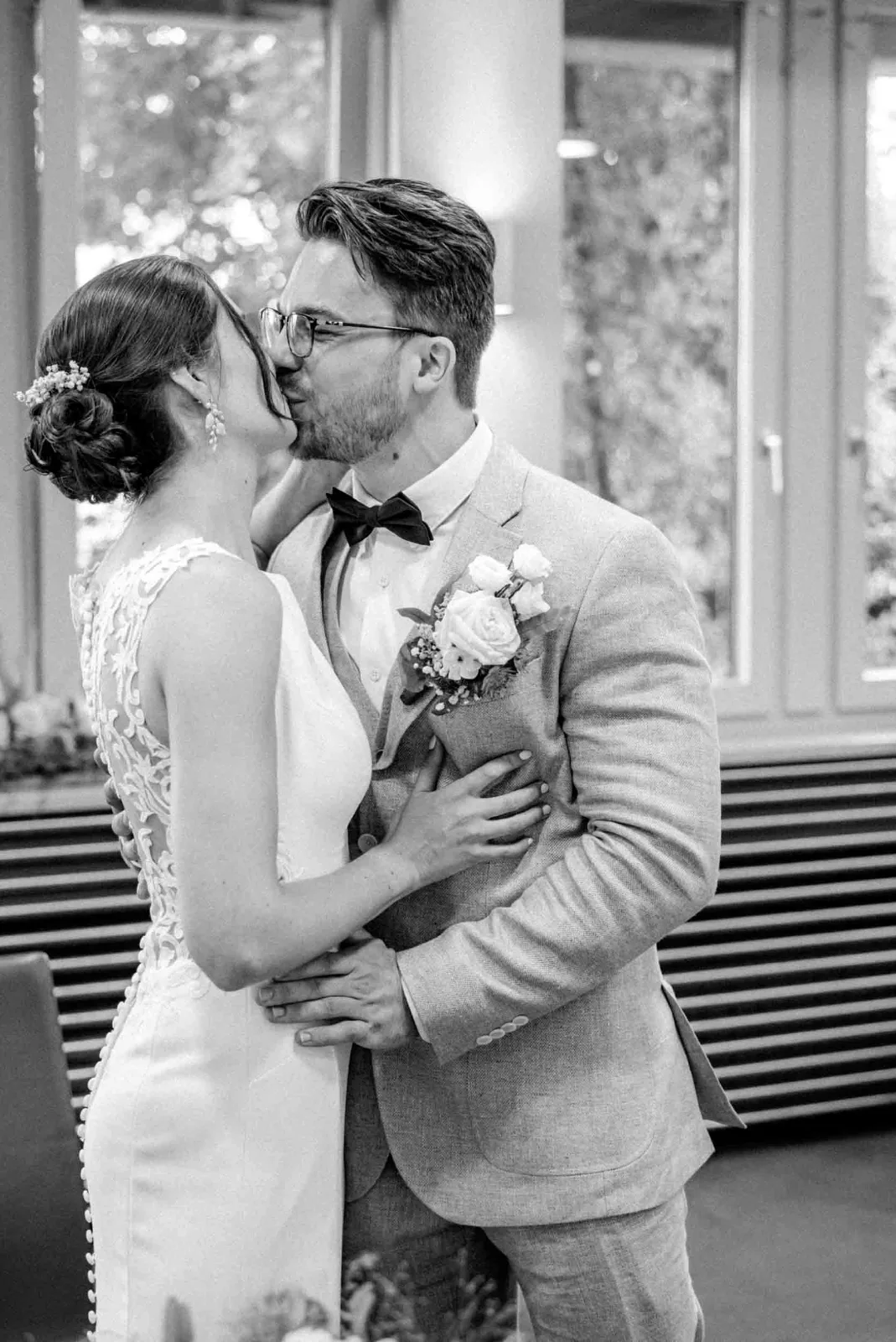 Ein Brautpaar küsst sich innig während seiner standesamtlichen Trauung in Poing, festgehalten von MOKATI als Hochzeitsfotograf München.