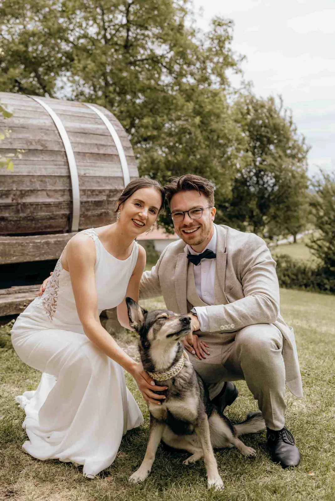 Als Hochzeitsfotograf München begleite ich das Brautpaar bei diesem entspannten Moment mit ihrem Hund im Freien in Landgut Kugleralm in Ebersberg.