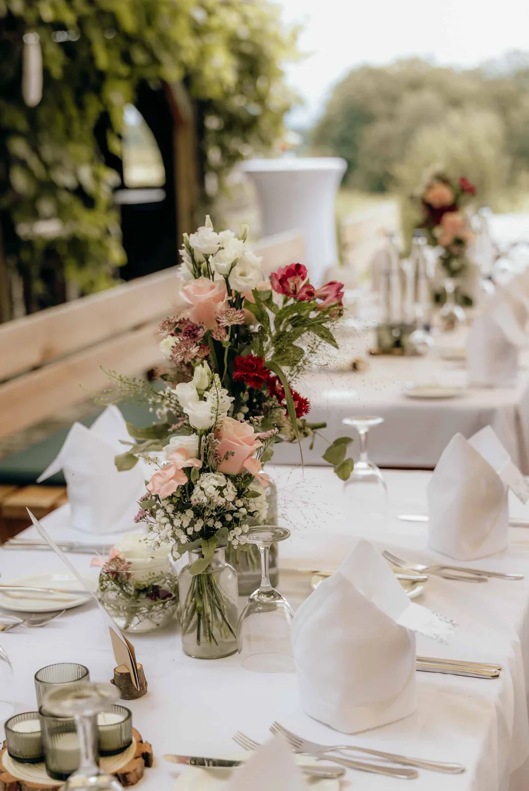 Blumendekoration auf einem festlich gedeckten Tisch bei einer Hochzeit, festgehalten von eurem Hochzeitsfotograf München.