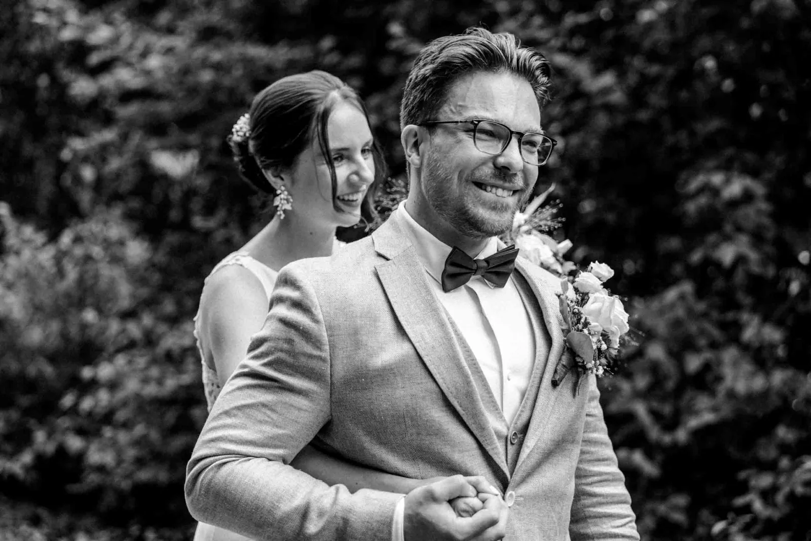 Ein Brautpaar umarmt sich innig im Wald, festgehalten von eurem Hochzeitsfotograf München auf den Weg zur Landgut Kugleralm.